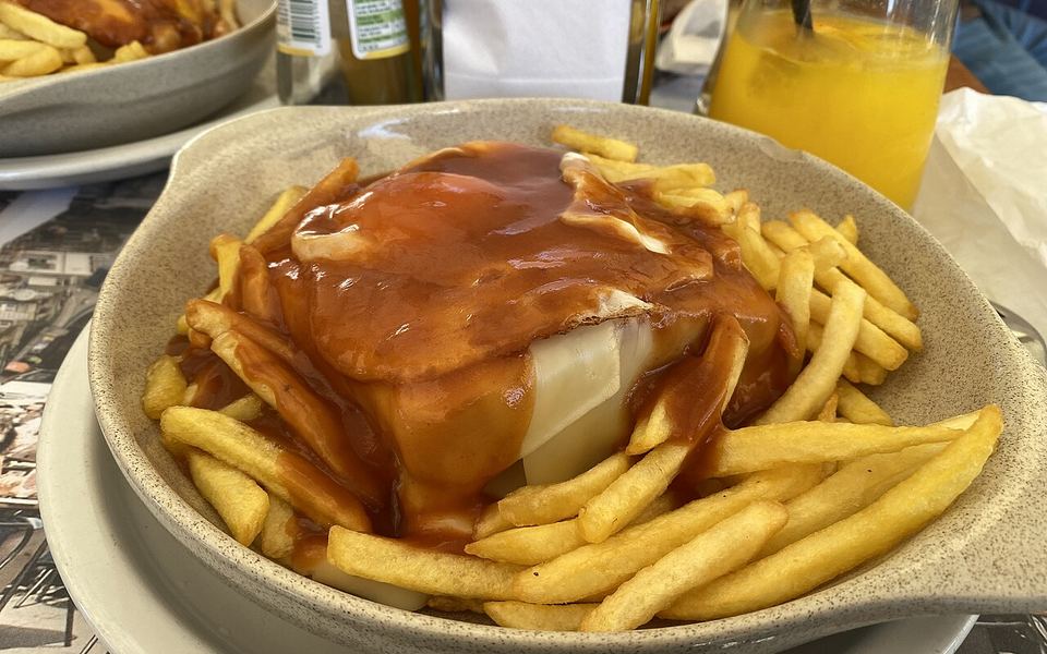 Francesinha com batatas fritas, prato típico do Porto